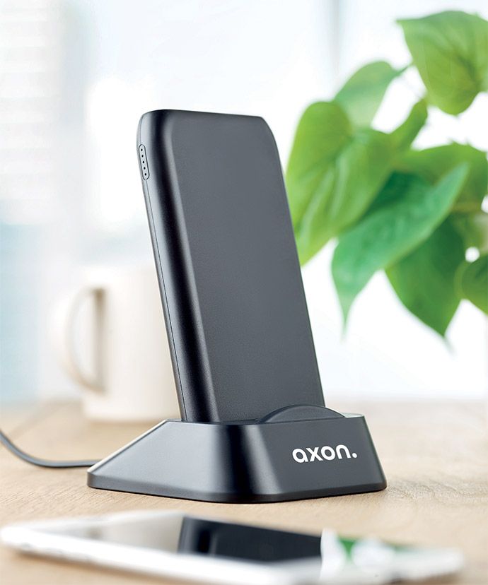 Svart, trådløs lader med trykk på et bord. Profileringsartikler til kontoret.